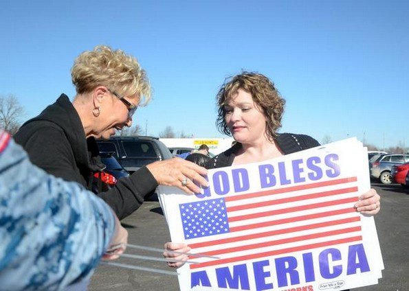 handing out god bless america signs pittsburg kansas