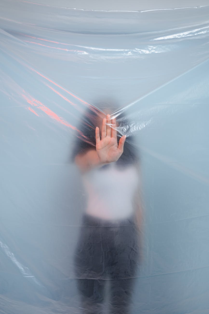 person in white top standing behind the plastic